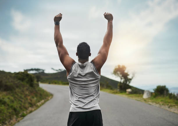 Rearview shot of an unrecognizable young sportsman cheering in celebration outside