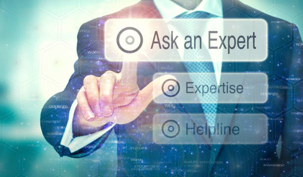 A businessman selecting a button on a futuristic display with a Ask an Expert concept written on it.