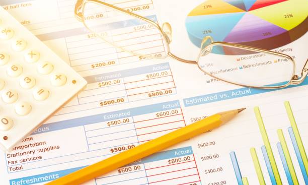 Pen, Eyeglasses and Calculator on Business Graphs and Charts