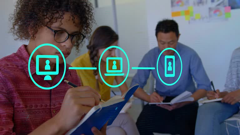Animation of three connected blue media icons over staff making notes in casual office meeting. global communication technology and data sharing concept, digitally generated