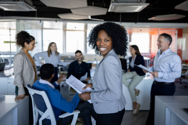 Portrait of a happy African American business woman in a meeting at the office and looking at the camera smiling