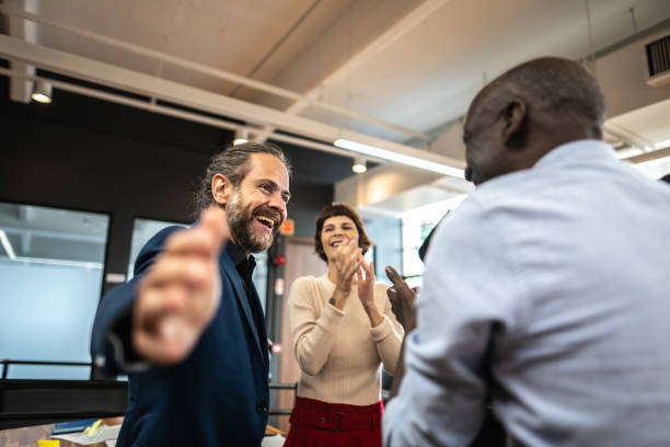 Coworkers celebrating and clapping on a meeting at office