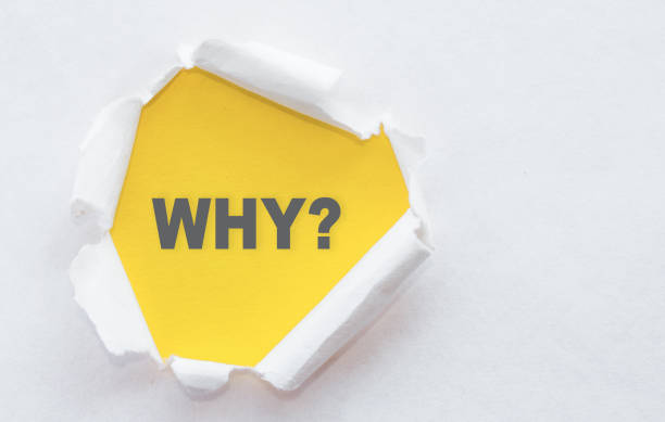 Top view of white torn paper and the text WHY? on a yellow background.