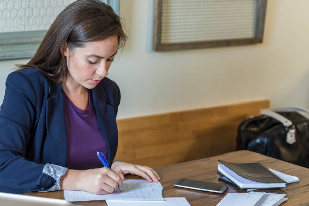 Young woman hand writing notes at her desk