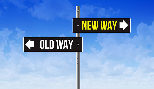 A conceptual illustration depicting a choice between a "NEW WAY" and an "OLD WAY," represented by two opposing road signs at a crossroads. Set against a blue sky, this image symbolizes the critical decision between innovation and tradition, progress and the past. This powerful visual metaphor is ideal for business presentations on strategy, change management, and digital transformation, as well as content exploring personal development and the courage to choose a different path.